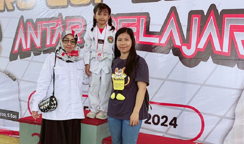 Kepala UPT SDN 169 Bayondo, Rismasari (kiri) foto bersama salah satu siswinya, Gharcheyla Boroallo yang meraih medali emas pada Tournament Taekwondo Batara Guru Cup Series II antar pelajar se Luwu Raya, di GOR Malili, Sabtu 21 September 2024.