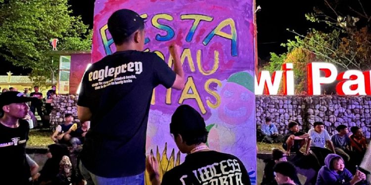 Seniman muda melukis mural 'Pesta Komunitas' di Malili, Sabtu 4 Mei 2025. Aksi ini jadi simbol kebebasan berekspresi dalam perayaan HUT ke-22 Luwu Timur. (Foto:Ist)
