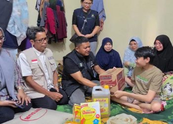 Pihak Dinsos P3A dan BPBD Lutim mengunjungi dan menyerahkan bantuan kepada Ashaq, pasien penderita Spina Bifida, di Desa Matano, Minggu 25 Mei 2025. (Foto: Dinas Kominfo SP Luwu Timur)
