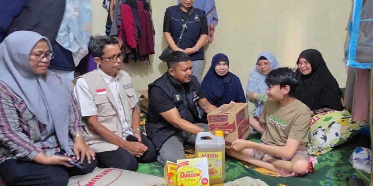 Pihak Dinsos P3A dan BPBD Lutim mengunjungi dan menyerahkan bantuan kepada Ashaq, pasien penderita Spina Bifida, di Desa Matano, Minggu 25 Mei 2025. (Foto: Dinas Kominfo SP Luwu Timur)