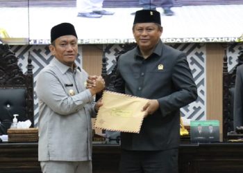 Bupati Luwu Timur, Irwan Bachri Syam menyerahkan lima ranperda yang diterima Ketua DPRD Lutim, Ober Datte, pada Rapat Paripurna DPRD, Rabu 21 Mei 2025. (Foto: Kominfo SP Lutim)