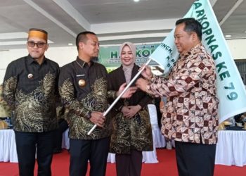 Kepala Disdagkop UKM Lutim, Senfry Oktavianus mewakil Bupati Luwu Timur menerima bendera pataka Harkopnas dari Gubernur Sulawesi Selatan, Andi Sudirman Sulaiman, di Lapangan Parang Passamaturukang, Jeneponto, Sabtu (23/08/2025). (Foto: Warta Lutim)