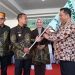 Kepala Disdagkop UKM Lutim, Senfry Oktavianus mewakil Bupati Luwu Timur menerima bendera pataka Harkopnas dari Gubernur Sulawesi Selatan, Andi Sudirman Sulaiman, di Lapangan Parang Passamaturukang, Jeneponto, Sabtu (23/08/2025). (Foto: Warta Lutim)