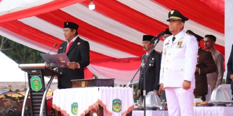 Ketua DPRD Luwu Timur, Ober Datte, membacakan teks proklamasi saat peringatan HUT ke-80 RI yang berlangsung khidmat di Lpangan Pendidikan Malili, Minggu 17 Agustus 2025. (Foto: Chullang_art)