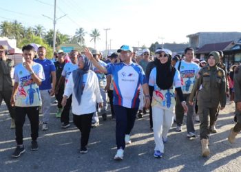 Bupati Luwu Timur, Irwan Bachri Syam, didampingi Ketua TP PKK, Ani Nurbani Irwan, mengikuti Jalan Sehat Juara Chapter 2 di Desa Manurung, Kecamatan Malili, Minggu 3 Agustus 2025. (Foto: Warta Lutim)