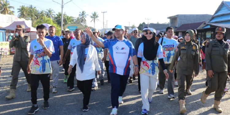 Bupati Luwu Timur, Irwan Bachri Syam, didampingi Ketua TP PKK, Ani Nurbani Irwan, mengikuti Jalan Sehat Juara Chapter 2 di Desa Manurung, Kecamatan Malili, Minggu 3 Agustus 2025. (Foto: Warta Lutim)