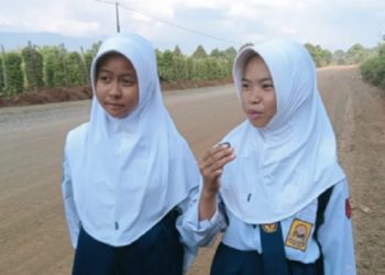 Dua pelajar menyampaikan apresiasi atas perhatian Pemkab Luwu Timur membenahi jalan Mahalona Raya. Foto: Warta Lutim