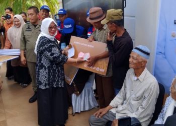 Wakil Bupati Luwu Timur, Puspawati Husler menyerahkan uang tunai pada pencairan perdana program Kartu Lansia di halaman Kantor Bupati Lutim, 30 Oktober 2025. Foto: Jaeja.id
