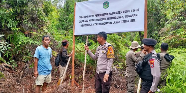 Pemkab Luwu Timur melalui Satpol PP memasang plang kepemilikan lahan di Desa Harapan, Kecamatan Malili, Sabtu (14/02/2026). Foto: Jaeja.id