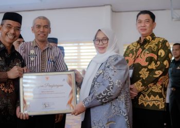 Wakil Bupati Luwu Timur, Puspawati Husler menyerahkan piagam penghargaan kepada Desa Baruga sebagai lokus Desa Cantik Luwu Timur tahun 2025, di Aula Dinas Pendidikan, Malili, Kamis (23/04/2026). Foto: Kominfo-SP