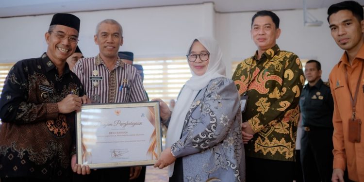 Wakil Bupati Luwu Timur, Puspawati Husler menyerahkan piagam penghargaan kepada Desa Baruga sebagai lokus Desa Cantik Luwu Timur tahun 2025, di Aula Dinas Pendidikan, Malili, Kamis (23/04/2026). Foto: Kominfo-SP