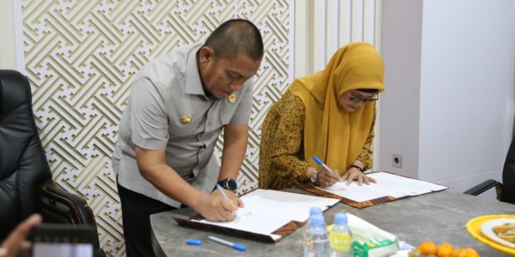 Bupati Luwu Timur, Irwan Bachri Syam dan Dirut PT Intim Technologia Sejahtera, Rianawati, menandatangani MoU stasiun pengisian kendaraan listrik di ruang kerja bupati, Sabtu (18/04/2026).