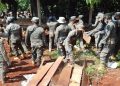Petugas mengumpulkan papan dan tiang bekas aran rumah warga dalam giat pengosongan lahan Laoli, Desa Harapan, Kamis (30/07/). Foto: inputrakyat