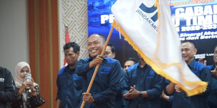 Ketua JMSI Luwu Timur, Jumaidil yang baru dilantik bersama jajaran pengurus lainnya, mengibarkan bendera pataka JMSI, di Aula Sasana Praja, Kantor Bupati Luwu Timur, Jumat (3/7/2026). Foto: IST