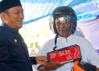 Bupati Luwu Timur, Irwan Bachri Syam, menyerahkan secara simbolis kendaraan dinas roda dua kepada petugas keagamaan pada peringatan Hari Jadi ke-14 Desa Wonorejo Timur, Kecamatan Mangkutana, Minggu (28/06/2026). Foto: Kominfo-SP