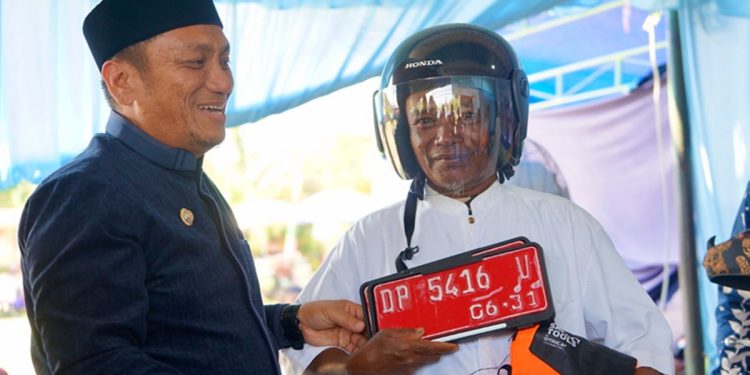 Bupati Luwu Timur, Irwan Bachri Syam, menyerahkan secara simbolis kendaraan dinas roda dua kepada petugas keagamaan pada peringatan Hari Jadi ke-14 Desa Wonorejo Timur, Kecamatan Mangkutana, Minggu (28/06/2026). Foto: Kominfo-SP
