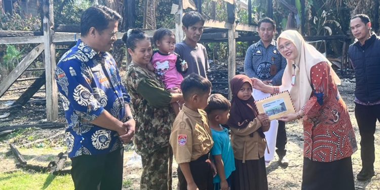 Kepala Disdikbud Luwu Timur, Raoda K Bersama sejumlah pengurus K3S Lutim memberikan bantuan kepada siswa korban kebakaran, Kamis (20/08/2026). Foto: IST