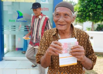 Seorang lansia di Kacamatan Burau baru saja menarik uang di ATM menggunakan Kartu Lansia Luwu Timur, Jumat (24/07/2028). Foto: Warta Lutim