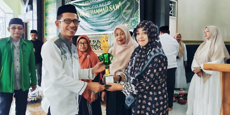 Camat Tomoni, Darwin HD memberikan trofi kepada pemenang lomba bunga male pada Peringatan Maulid Nabi Muhammad SAW 1448 H di Masjid Besar Al Anshor, Tomoni, Selasa (25/08/2026). Foto: jaeja.id