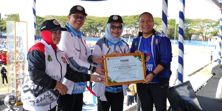 Bupati Luwu Timur Irwan Bachri Syam menerima penghargaan dari PGRI Sulawesi Selatan pada pembukaan Porsenijar 2026 di Sidrap, Kamis (2/07/2026). Foto: Warta Lutim